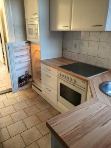 a kitchen with a stove top oven next to a sink at Ingrid&primes Ferienwohnung in Erfde