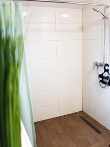 y baño con ducha de azulejos blancos. en Exklusives Ferienhaus Hamburg West!, en Hamburgo