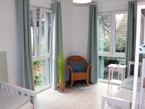 a room with a chair and large windows at Exklusives Ferienhaus Hamburg West! in Hamburg