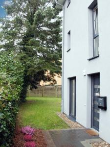 una casa blanca con un patio de césped al lado de un edificio en Exklusives Ferienhaus Hamburg West!, en Hamburgo