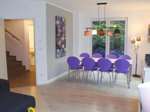 comedor con sillas de color púrpura y mesa en Exklusives Ferienhaus Hamburg West!, en Hamburgo