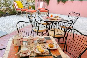 a table and chairs with plates of food on it at Rosegarden Essence Sintra - by Unlock Hotels in Sintra