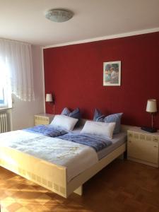 ein Schlafzimmer mit einem großen Bett mit einer roten Wand in der Unterkunft Ferienhaus Störzel Wohnung A in Morbach