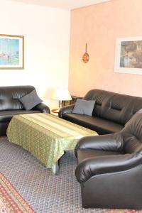 sala de estar con 2 sofás de cuero y 1 cama en Haus Strandfee - App 12 en Grömitz