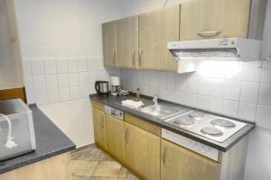 uma pequena cozinha com um lavatório e um fogão em An der Galerie, B 02 em Zingst