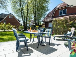 a patio with a table and chairs in a yard at Birkenstraße 6 Haus I Whg 1 in Zingst
