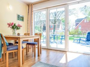 a dining room with a table and chairs and sliding glass doors at Birkenstraße 6 Haus I Whg 1 in Zingst