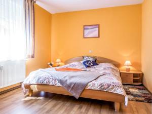 a bedroom with a bed with yellow walls and a window at Birkenstraße 6 Haus I Whg 1 in Zingst