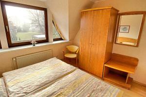 1 dormitorio con 1 cama, armario y ventana en Sievert, Dietmar en Zingst
