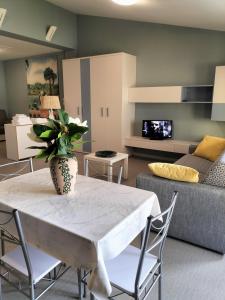 un soggiorno con tavolo e divano di Attico Open Space - Piscina a 400 mt a Desenzano del Garda