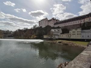 une rivière en face d'un bâtiment avec un château dans l'établissement Ferienwohnung Neu "Zum Westerwald" LAHN01, à Löhnberg