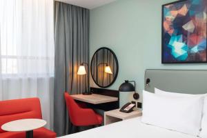 a hotel room with a large bed and a television at Hyatt Place London City East in London