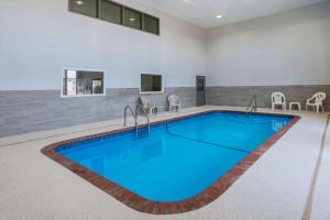 a swimming pool in a building with a blue pool at Super 8 by Wyndham Amarillo West in Amarillo