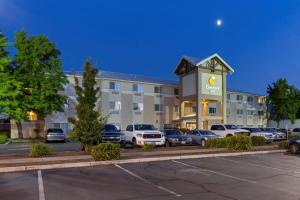 a hotel with cars parked in front of a parking lot at Comfort Inn South-Medford in Medford