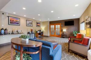 a living room with a blue couch and a table at Comfort Inn South-Medford in Medford