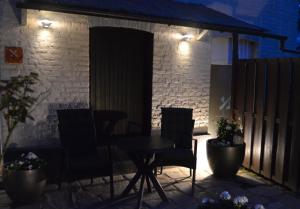 un tavolo e sedie su un patio di notte di Le BELLEA a Verviers