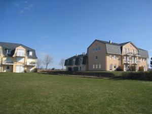 eine Reihe von Häusern in einem Hof mit einem grünen Feld in der Unterkunft Fehmarnstrand 78 App 9 in Staberdorf