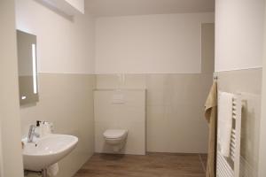 ein weißes Bad mit einem WC und einem Waschbecken in der Unterkunft Casa Kronengarten Nr 1 in Hilden