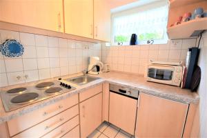 a small kitchen with a sink and a microwave at Haus Antje-Kellenhusen Whg3 in Kellenhusen