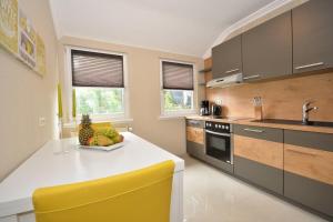 a kitchen with a white counter and a yellow chair at Business Apartments Bremen Typ 4 in Bremen