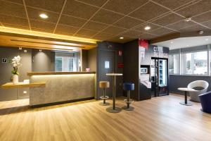 a lobby with a counter and stools in a room at Ibis Budget Bourgoin Jallieu Centre in Bourgoin