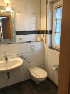 a white bathroom with a toilet and a sink at Strandmuschel - a05355 in Zingst