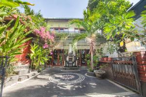 een binnenplaats met veel planten en een hek bij Pondok Taksu Bali in Kuta