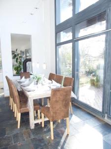 a dining room with a white table and chairs at Ferienhaus Sonnenaufgang in Walsrode