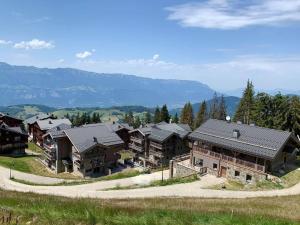 a group of houses with mountains in the background at Les 7 laux immobilier chalet F in Prapoutel