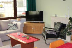 Una sala de estar con un televisor, un sofá y una mesa. en Haus Erlen, en Olsberg 7 fotos más