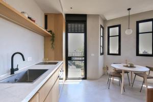 a kitchen with a sink and a table in it at AYA Boutique Aparthotel in Tel Aviv