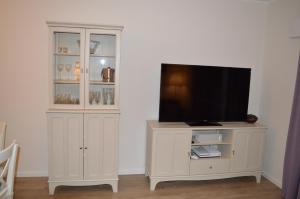 a television on a white cabinet in a room at Ferienwohnung 2404 App 1 in Burhave in Burhave