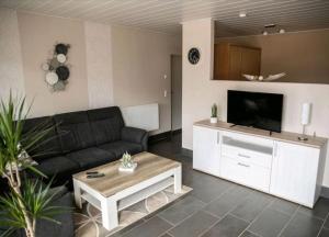 uma sala de estar com um sofá e uma televisão em Ferienwohnung Kleine Gasse em Lathen