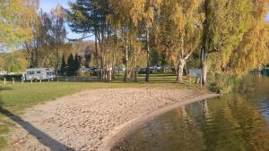 una playa en un parque junto a un río en Baumzelt en Wittenborn