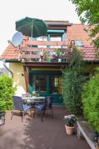 une terrasse avec une table, des chaises et un parasol dans l'établissement Harzglück, à Thale