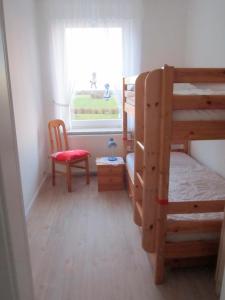 a bedroom with two bunk beds and a window at "Ferienhof Sporleder" - Bauernhaus 2 in Meeschendorf
