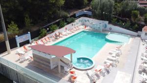 una vista aérea de una piscina con sillas y una mesa en Villaggio Elisena, en Vieste