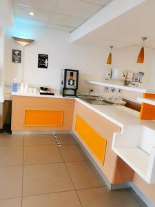 a kitchen with an orange and white counter top at Ecomotel Grayston previously known as SUN1 Wynberg in Johannesburg
