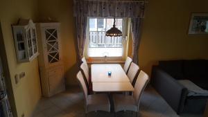 d'un salon avec une table, des chaises et une fenêtre. dans l'établissement Haus Michel, à Nordstrand