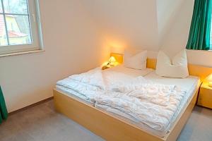 een klein bed in een kamer met een raam bij Am Deich 49 in Zingst