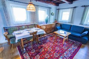 ein Wohnzimmer mit einem Tisch und einem Sofa in der Unterkunft Soldanella 2 by Alpenidyll Apartments in Ramsau am Dachstein