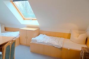 ツィングストにあるAm Deich 49のベッドと窓が備わる小さな客室です。