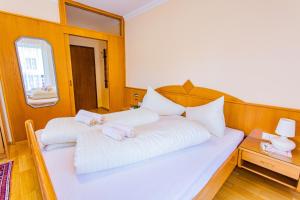 ein Schlafzimmer mit einem weißen Bett mit weißen Kissen in der Unterkunft Soldanella 2 by Alpenidyll Apartments in Ramsau am Dachstein