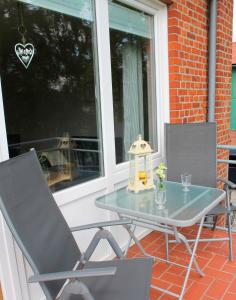 a glass table and two chairs on a porch at Landhaus Lippmann Whg4 in Grönwohldshorst
