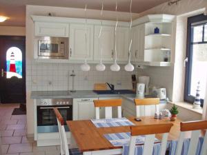 a kitchen with a wooden table and a dining room at "Leuchtturm" in Fuhlendorf