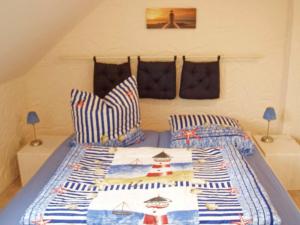 a bedroom with a bed with striped pillows at "Leuchtturm" in Fuhlendorf