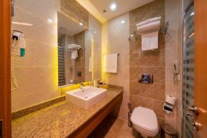 a bathroom with a sink and a toilet and a mirror at Sundia By Liberty Oludeniz in Oludeniz