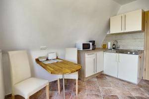 uma pequena cozinha com uma mesa de madeira e um micro-ondas em Haus Havelland em Zingst