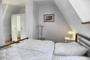 a bedroom with a white bed and a staircase at Haus Havelland in Zingst