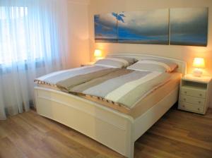 グレーミッツにあるSeepark - Backbordのベッドルーム(ランプ2つ付)の大きな白いベッド1台